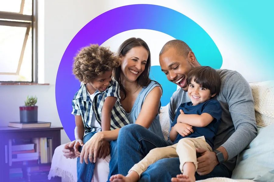 Parents and their daughter laughing together on the sofa at home