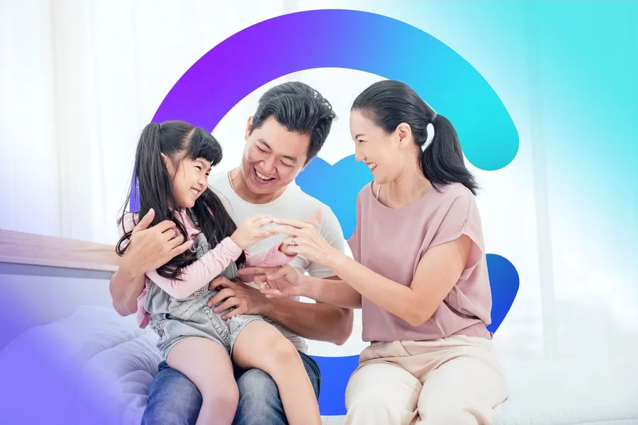 Parents tickling their laughing child on the sofa, framed by the Catilize C